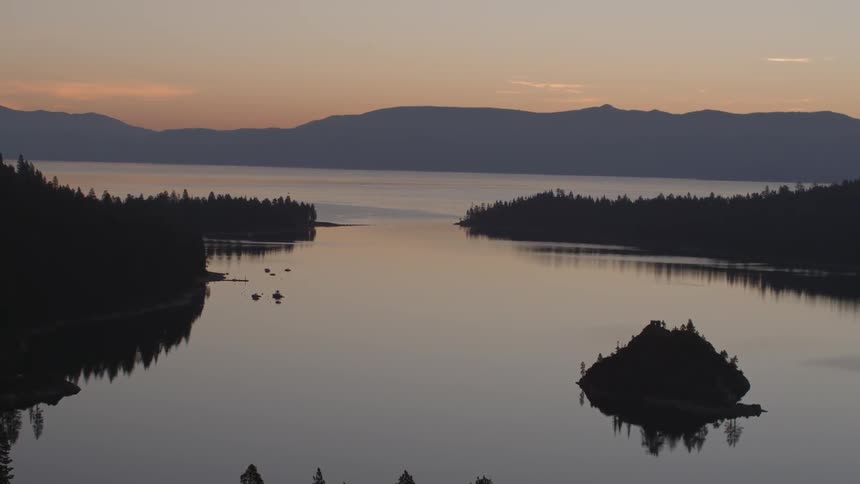 The lake is calm at sunset below