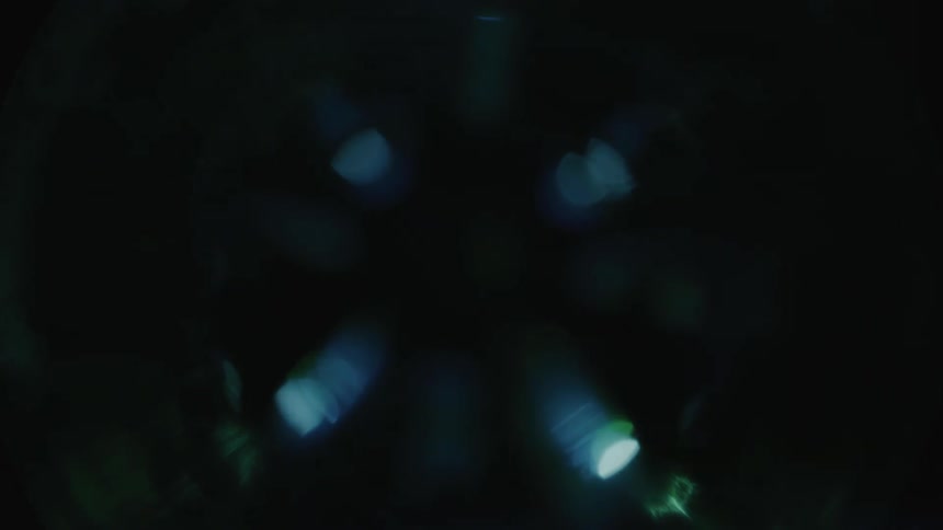 Blue and green lights shimmer on lens