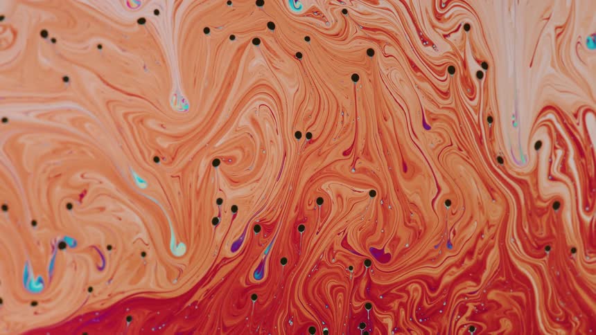 An orange liquid with black dots moving randomly