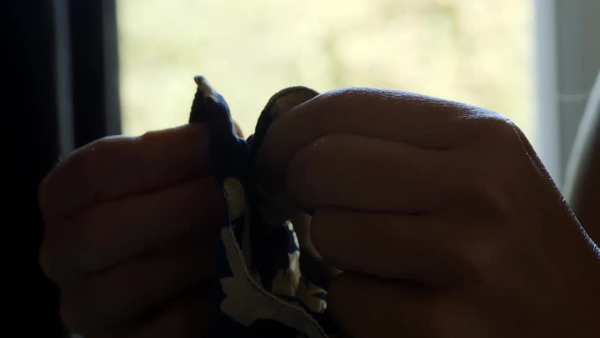 Close up of the hands of a woman handling a piece of cloth