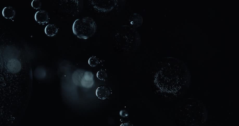 Circular bubbles floating in liquid in the dark