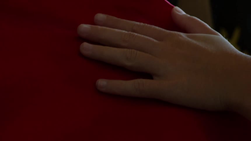 Someones hands rubbing on a silk cloth indoor