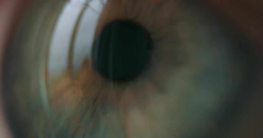 A persons eyes are reflecting light and they blink