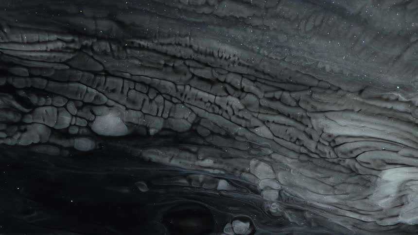 White ink creates cracked shapes over a dark background