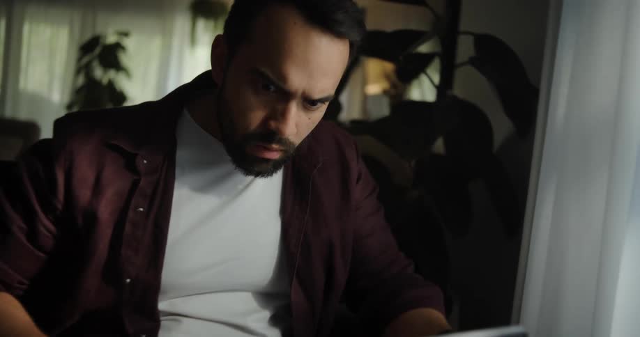 Man acts surprised reading something on a laptop
