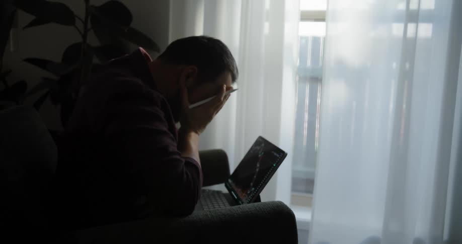 An angry man with a laptop on his lap