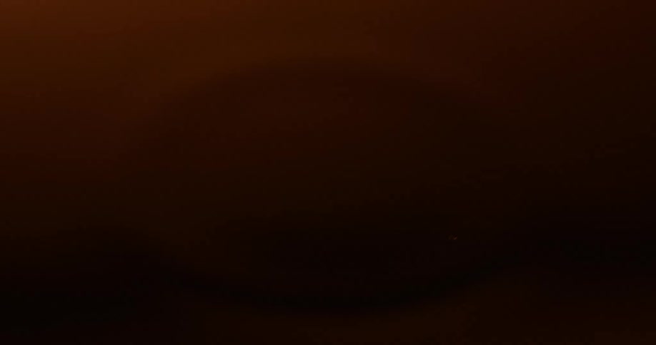 A dark room is faint light showing a drop of water into a larger water body