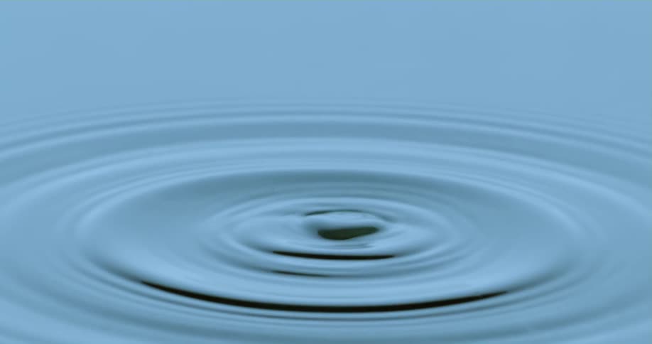Drop falls on water splashing and rippling