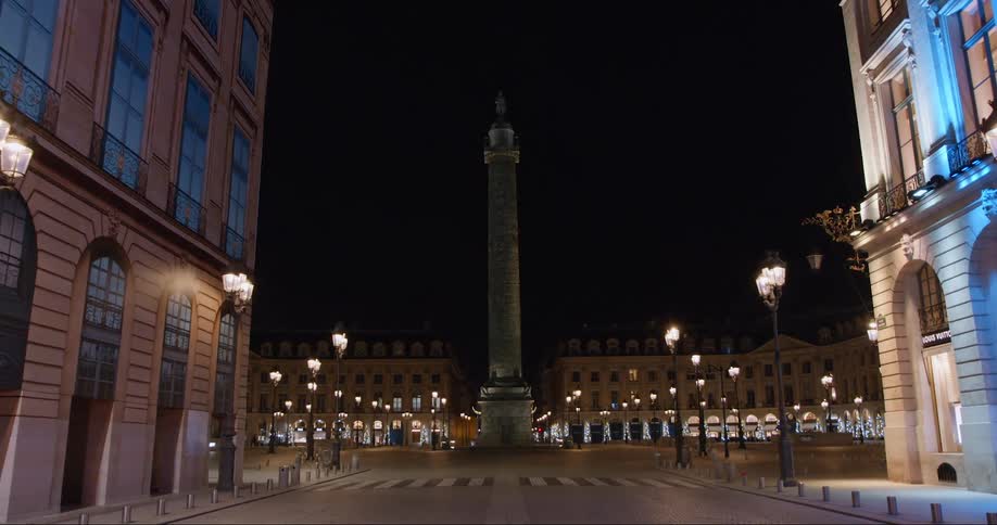 A statue is on a pillar in the middle of the city
