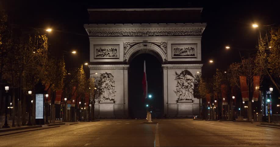 A monument with a french flag at night