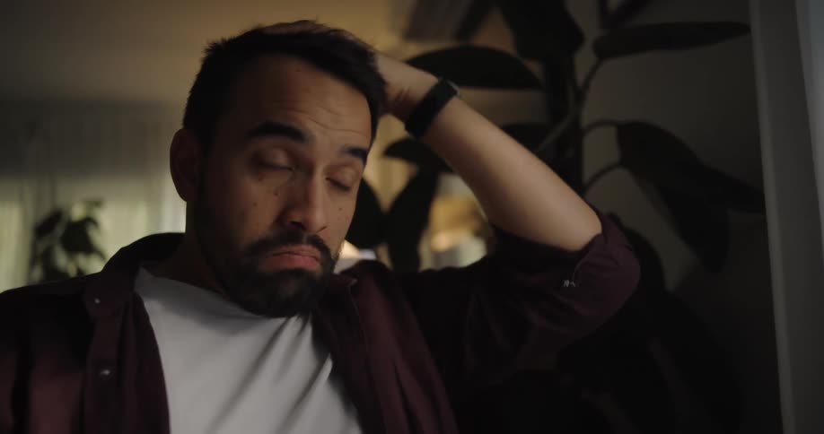 A man sits in a room looking contemplative