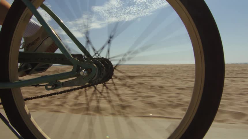 Person cycling outdoors on a road next to the desert during day time