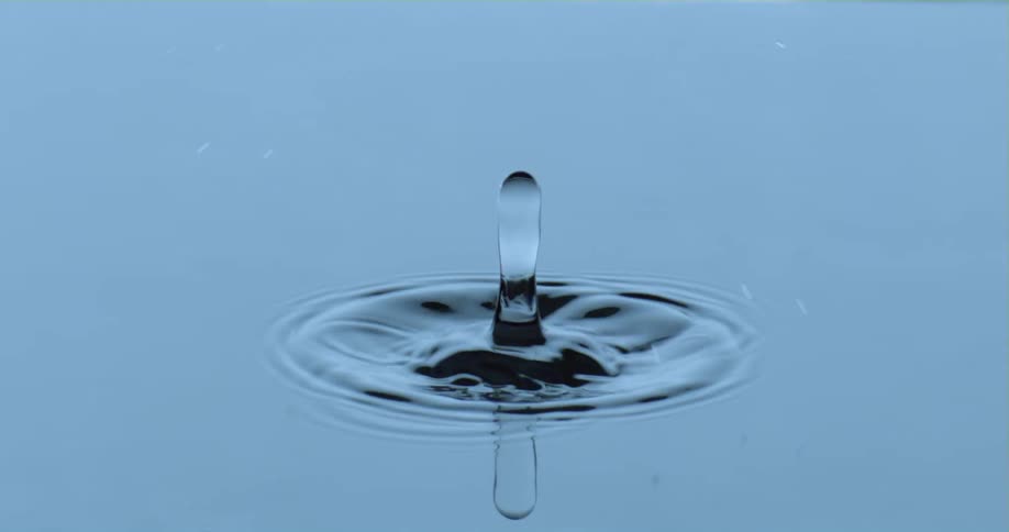 A drop of water falling into a pool of water causing ripples