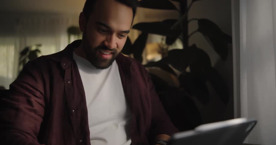 A man working and smiling on his device