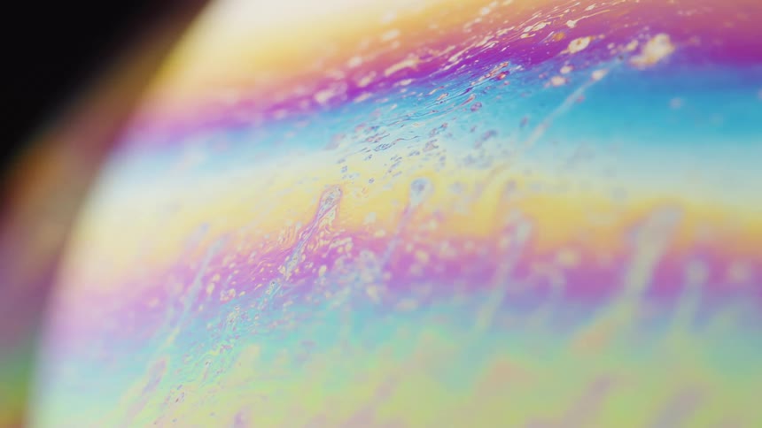 Rainbow colored liquids spin around in a sphere