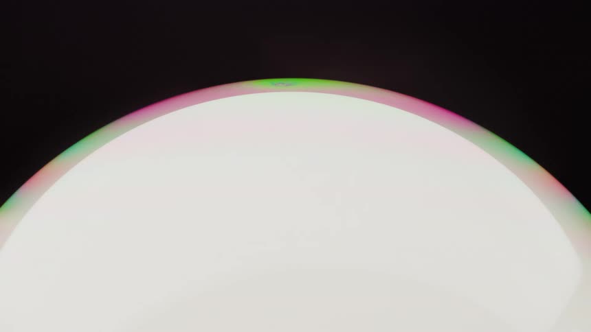 Round light with colored edges on a black background
