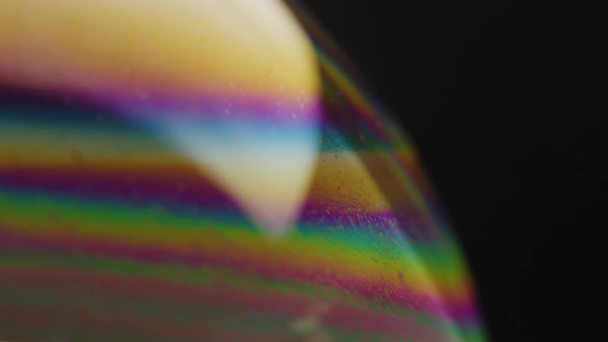 Transparent rainbow colored lines reflect off a smooth surface