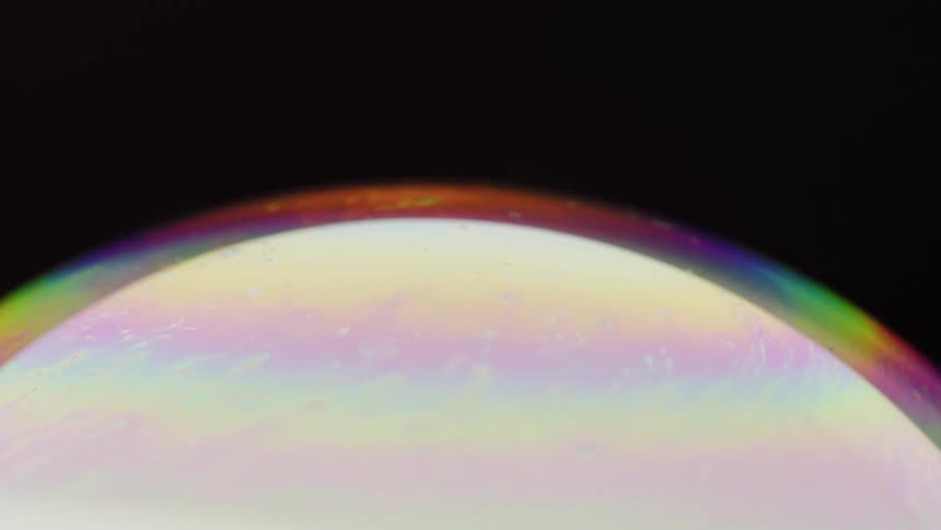 A sphere rotating in dark space surrounded by rainbow colors