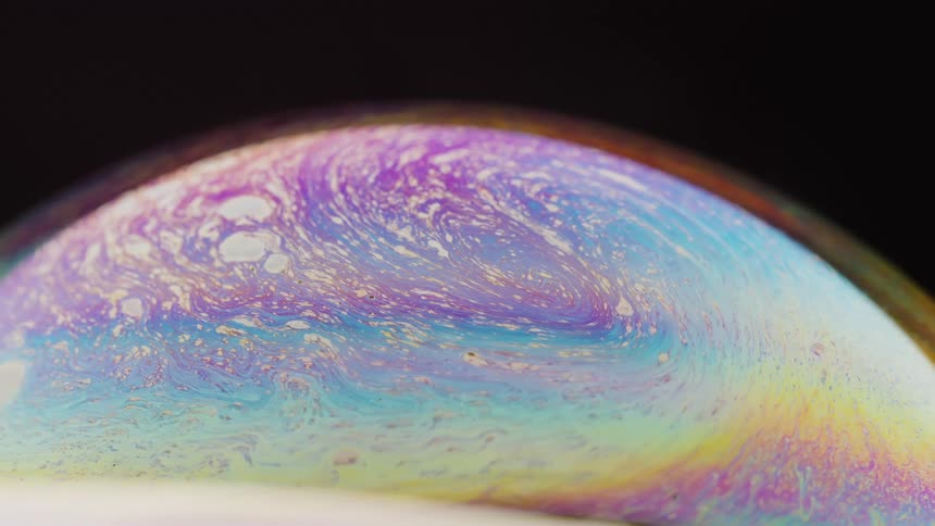 Multicolored swirls flow on surface of sphere against a black background