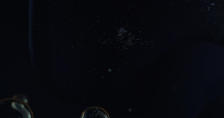 Bubbles float in the darkness as a large orb explodes