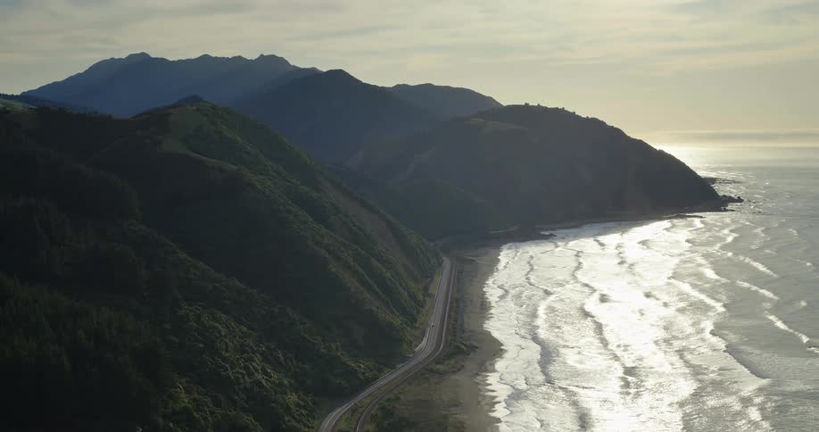 A beach and a mountain separated by a road