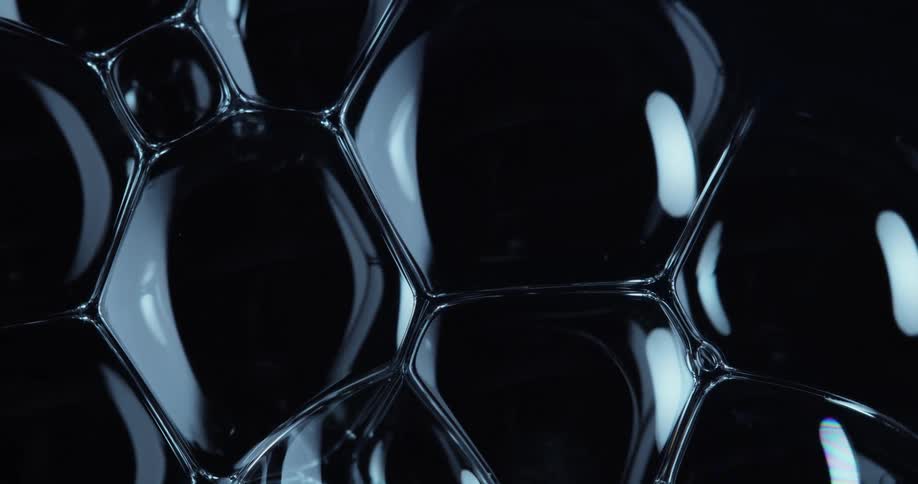 Dense and abstract bubbles colliding with each other on a black background