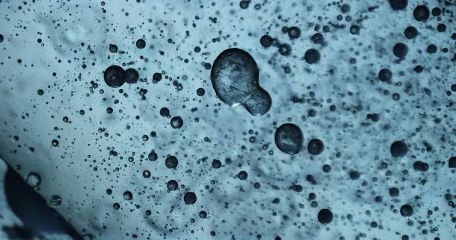 Abstract light blue bubbles on a liquid surface