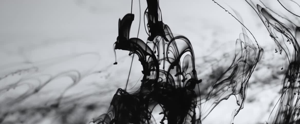 Black ink flows in translucent liquid