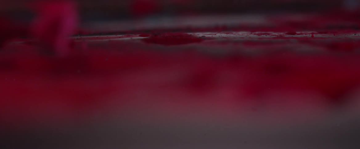 Droplet falling into a dense and abstract red liquid