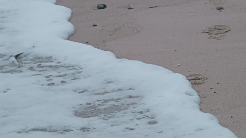Waves with foam hitting the coast