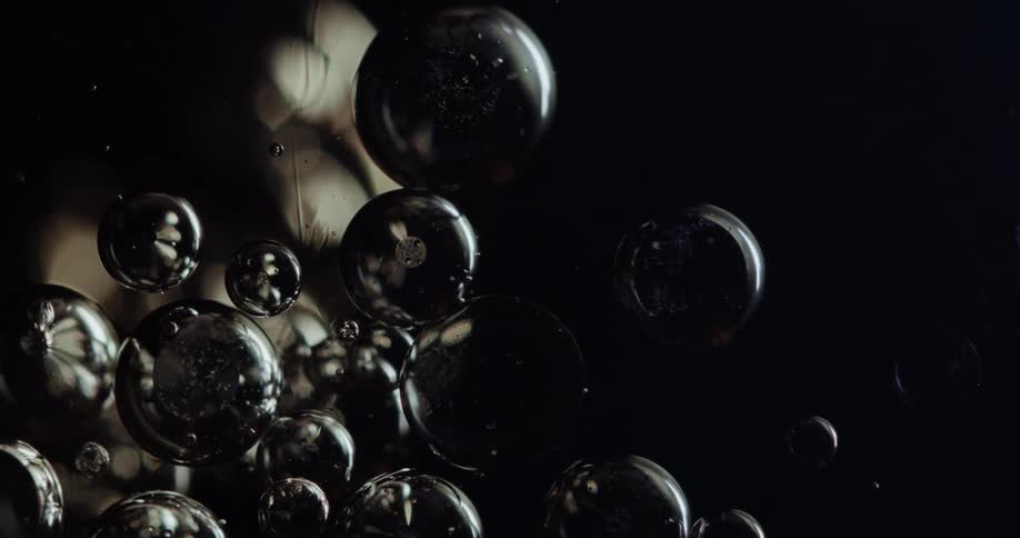 Bubbles floating in a shiny black liquid