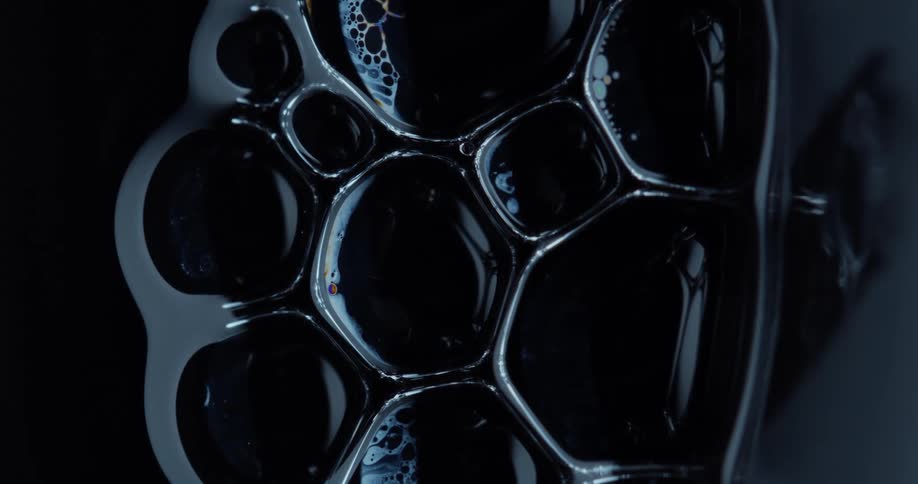 Dense and abstract bubbles colliding with each other on a black background