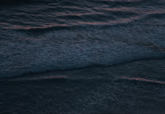 Ocean waves on a beach at sunset