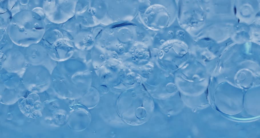Air bubbles float down a thick blue liquid