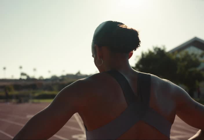 A young woman walking on a track after a race