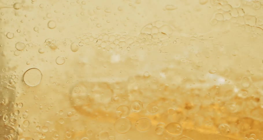 Air bubbles float on a thick yellow liquid