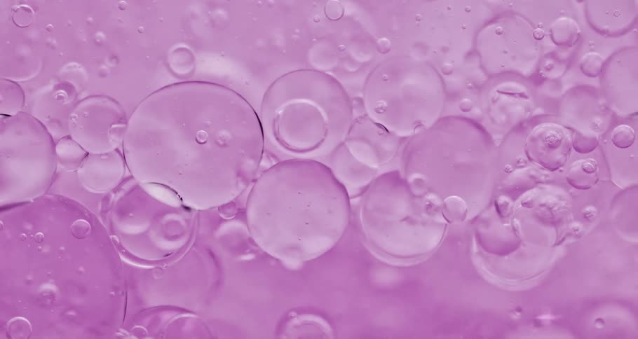 Air bubbles rising on a purple liquid
