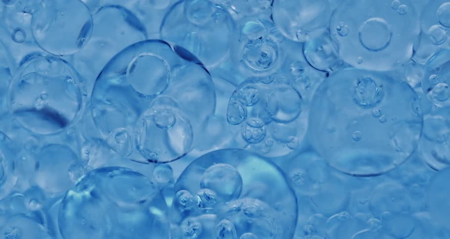 Groups of bubbles floating in blue liquid