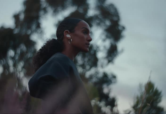 A woman wearing hearing aids stands in a field of flowers