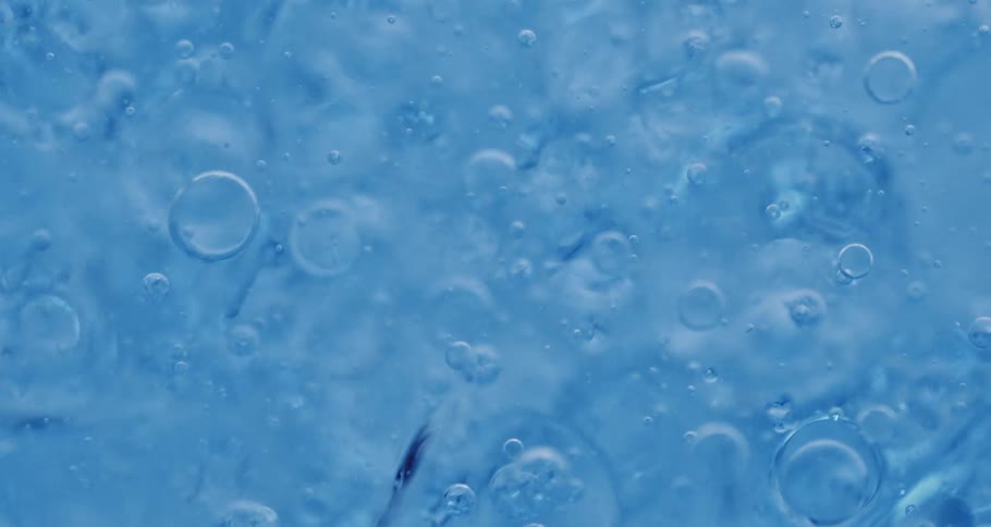 Air bubbles float down a thick blue liquid
