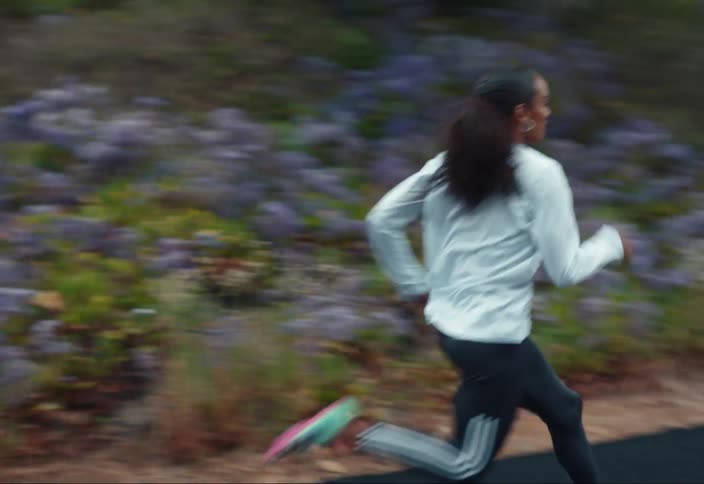 A woman sprints on the side of a road