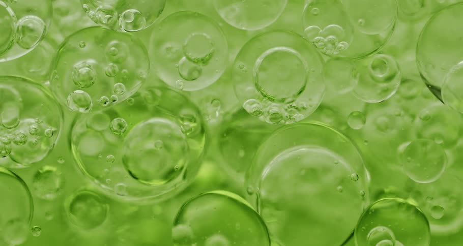 Clear orbs with bubbles inside float in a lime green liquid
