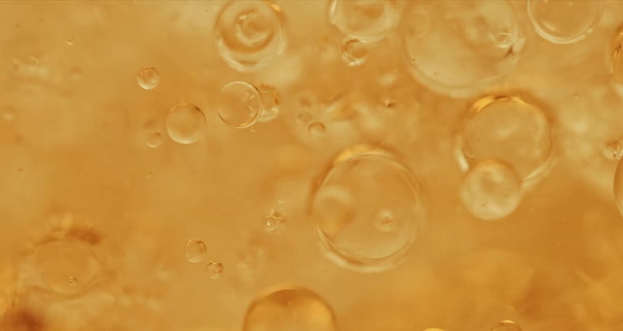 Air bubbles float on a thick yellow liquid