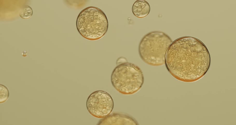Yellow bubbles floating down a clear liquid