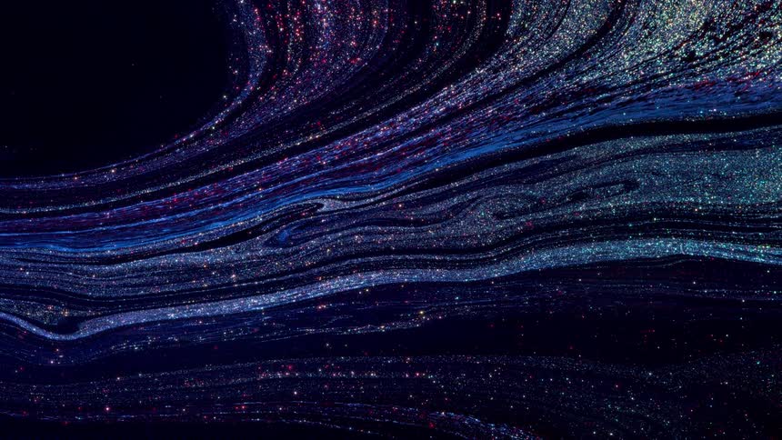 Blue and white glitter paint slowly streaming across a black canvas