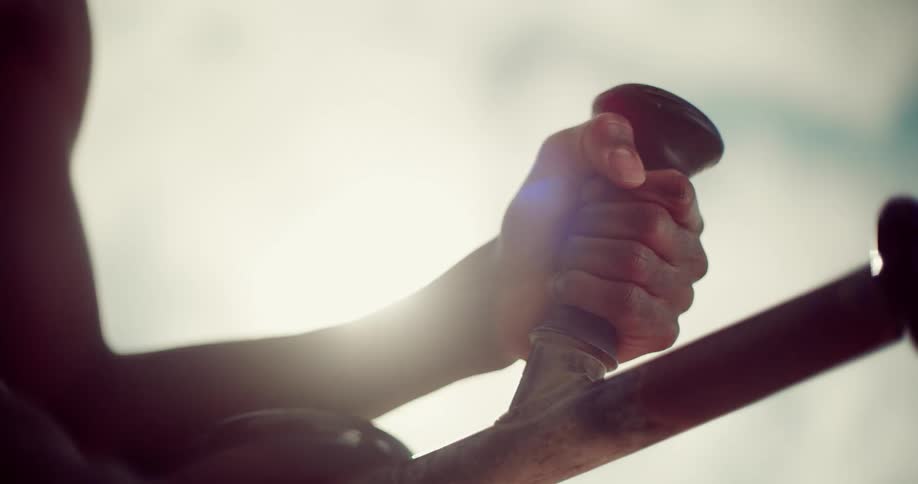 Closeup of a persons hands resting on a device and performing abdominal exercises by lifting their legs