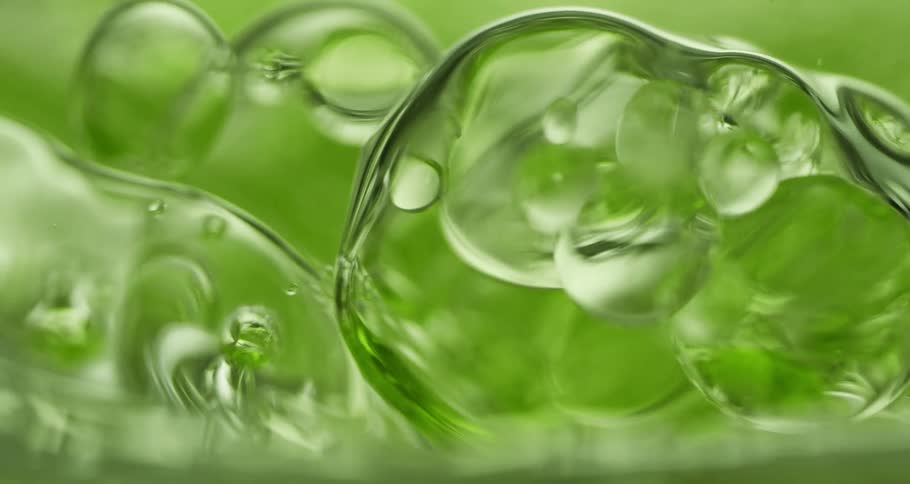 Bubbles in green liquid flow and reflect light