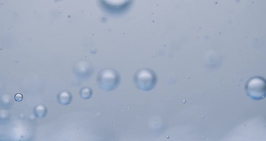 Small bubbles float through translucent blue liquid