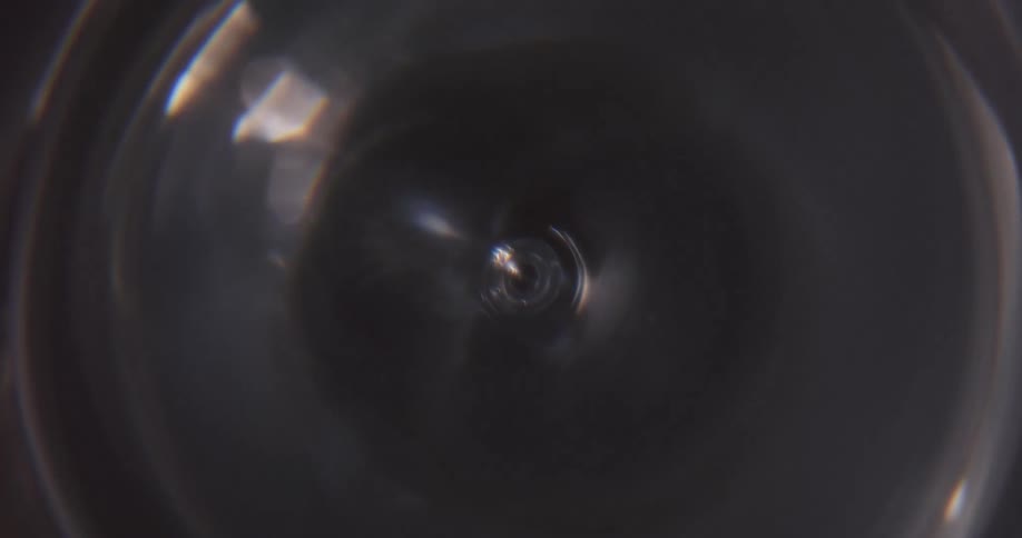 Light shines fading in and out onto a fan on high speed with blades that looked blurred