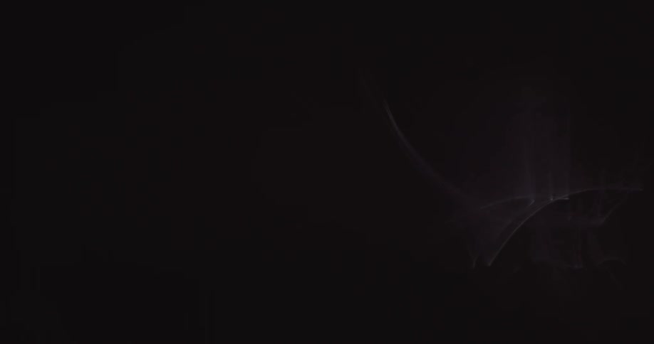 Shimmering silver shapes and light glow and fade against black